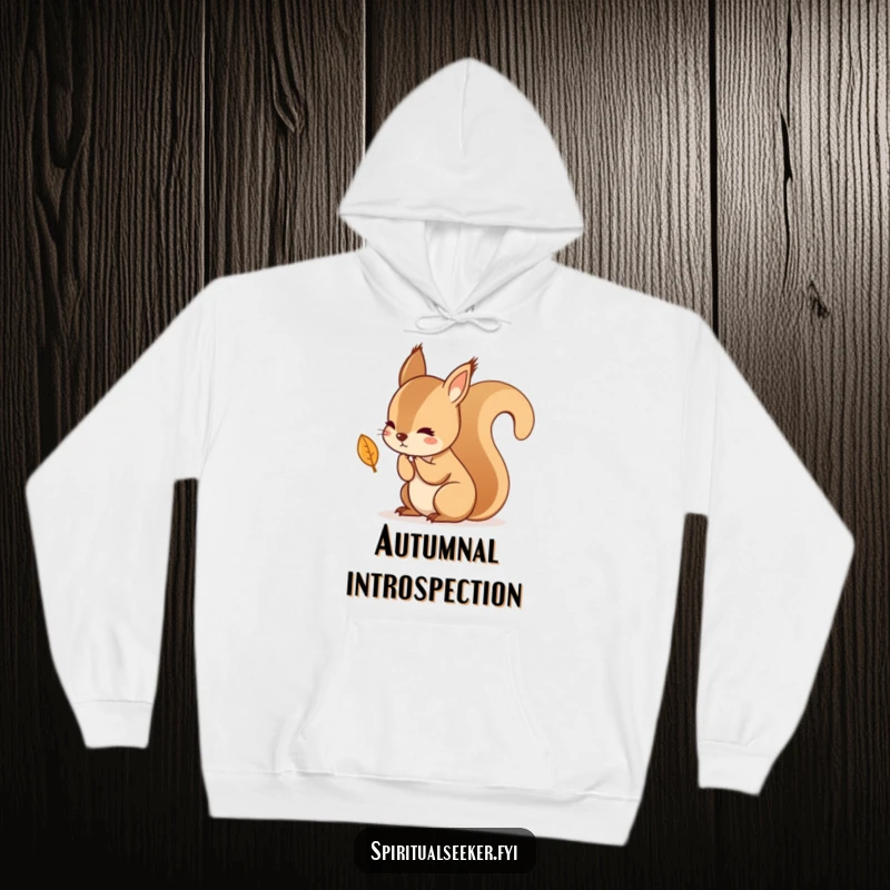 Funny, cozy hoodie depicting a kawaii squirrel in deep thought about a falling leaf, offering warmth and autumnal introspection.